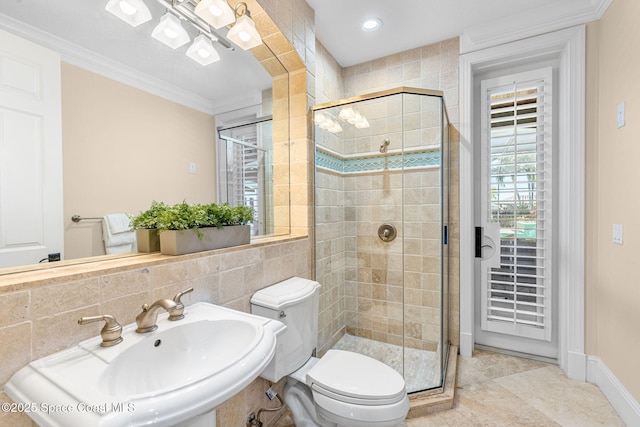 full bathroom with a sink, toilet, a shower stall, and crown molding