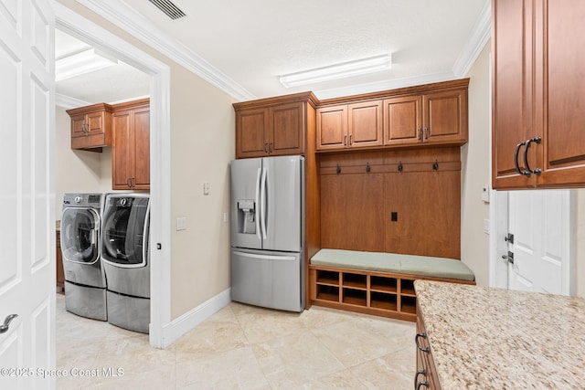 kitchen featuring washer and clothes dryer, brown cabinetry, stainless steel refrigerator with ice dispenser, and ornamental molding