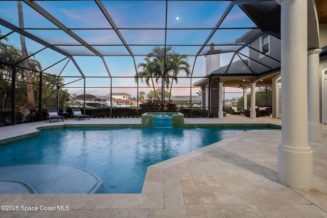 view of pool featuring glass enclosure, a patio, and a pool with connected hot tub