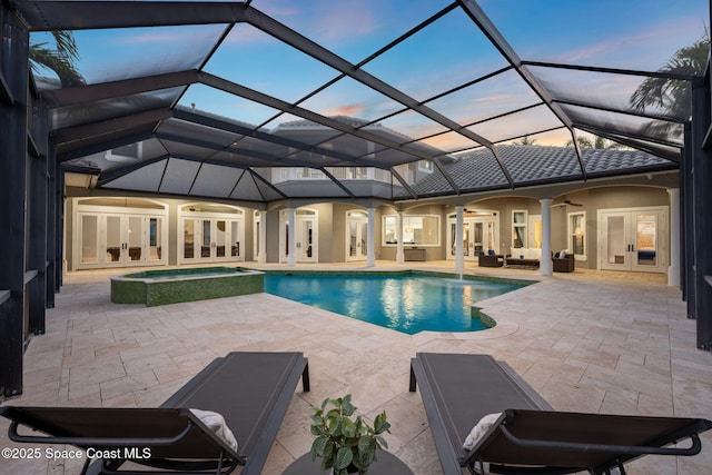 pool at dusk featuring a lanai, french doors, outdoor lounge area, a ceiling fan, and a patio