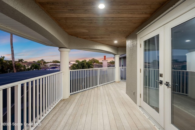 deck at dusk featuring french doors