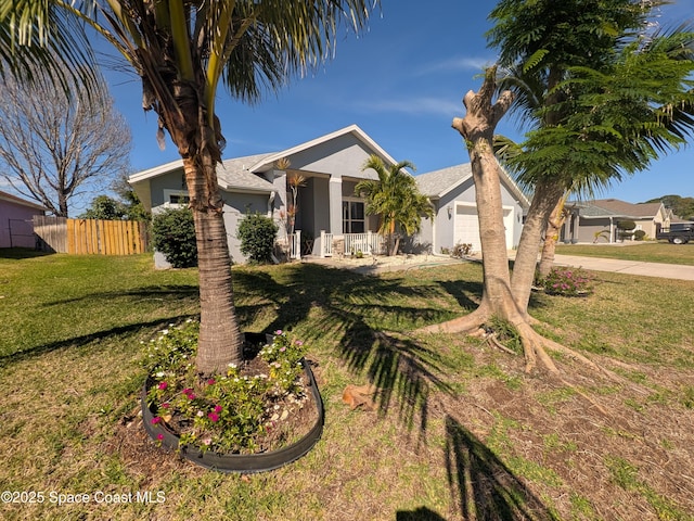 view of front facade featuring stucco siding, concrete driveway, a front yard, fence, and a garage