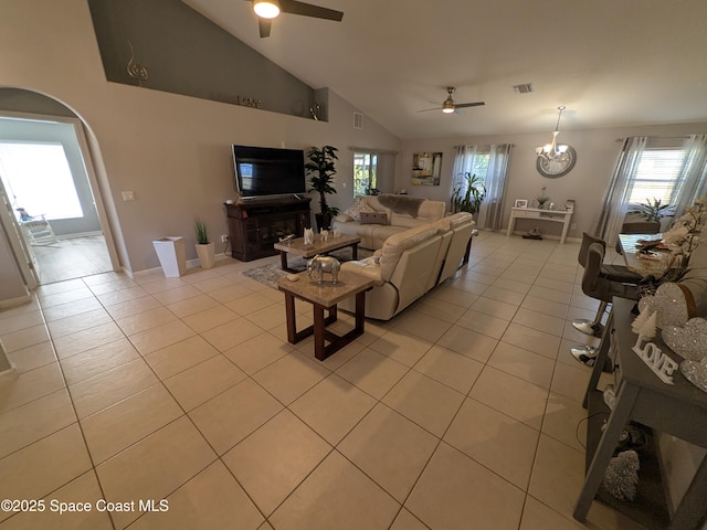 living room with arched walkways, ceiling fan with notable chandelier, light tile patterned flooring, and visible vents