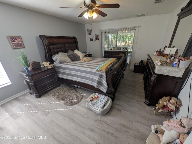 bedroom featuring visible vents, ceiling fan, baseboards, and wood finished floors