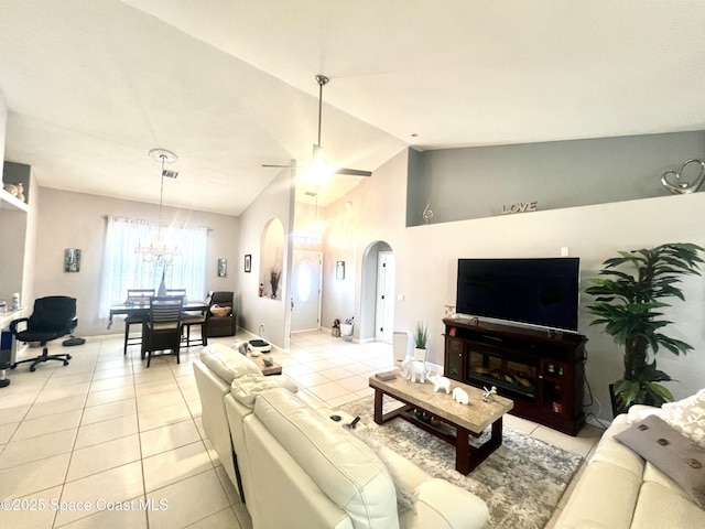 living room with arched walkways, light tile patterned floors, visible vents, high vaulted ceiling, and ceiling fan with notable chandelier