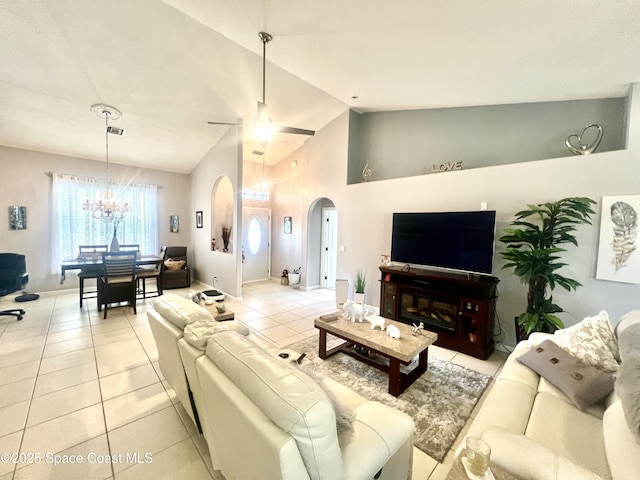 living room featuring light tile patterned floors, visible vents, arched walkways, high vaulted ceiling, and ceiling fan with notable chandelier