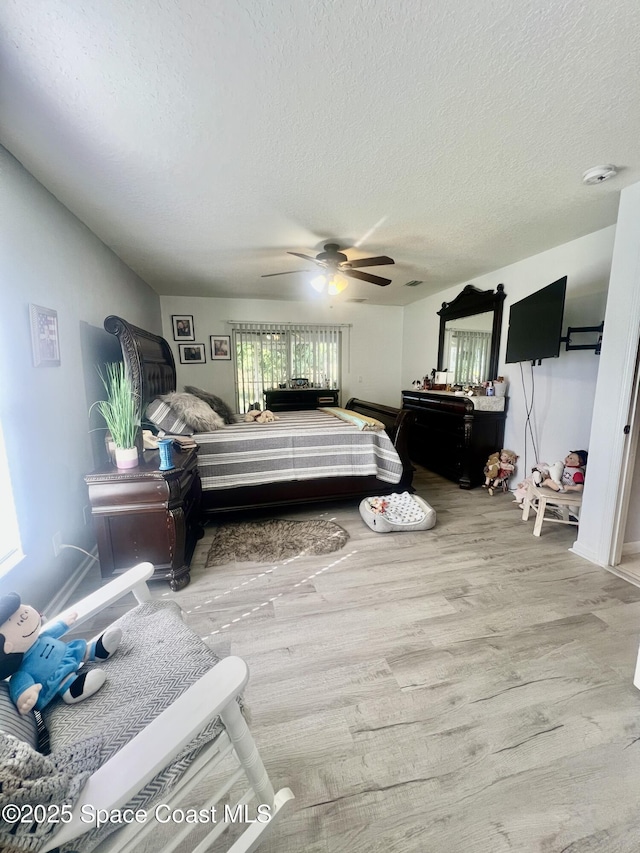 bedroom featuring a ceiling fan, a textured ceiling, and wood finished floors