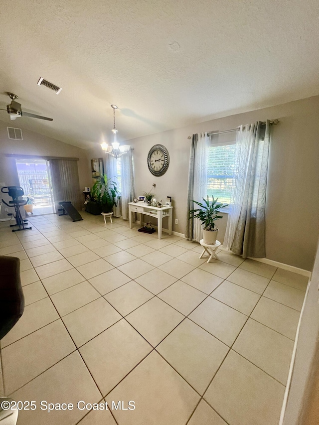 unfurnished dining area featuring a healthy amount of sunlight, visible vents, a textured ceiling, and light tile patterned flooring