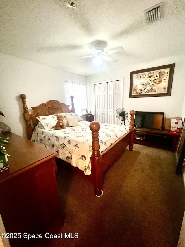 carpeted bedroom featuring a closet, visible vents, ceiling fan, and a textured ceiling