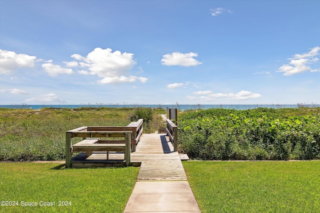 view of community featuring a water view and a lawn