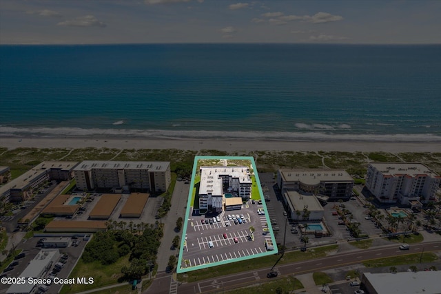 drone / aerial view featuring a water view and a beach view