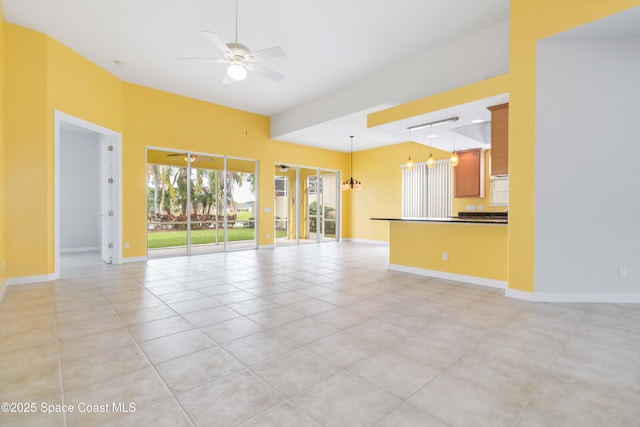 unfurnished living room with ceiling fan, light tile patterned floors, and baseboards