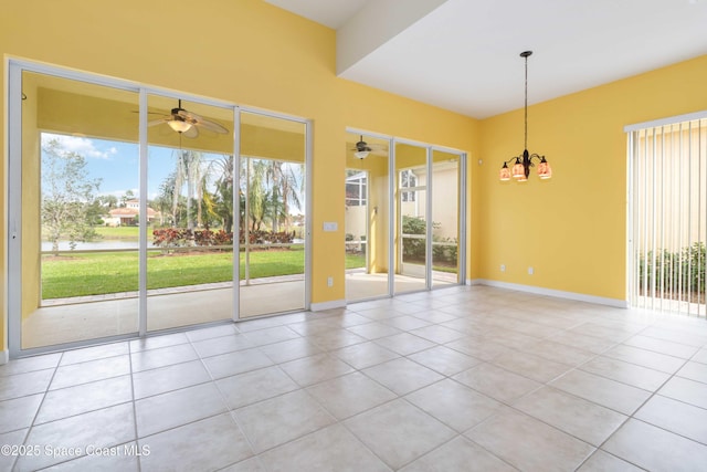 tiled spare room featuring ceiling fan and baseboards