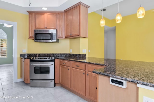 kitchen with appliances with stainless steel finishes, dark stone counters, visible vents, and hanging light fixtures