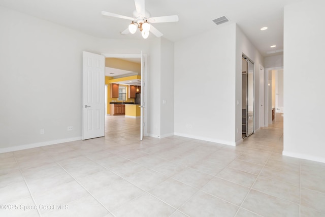 spare room featuring a barn door, visible vents, baseboards, ceiling fan, and recessed lighting