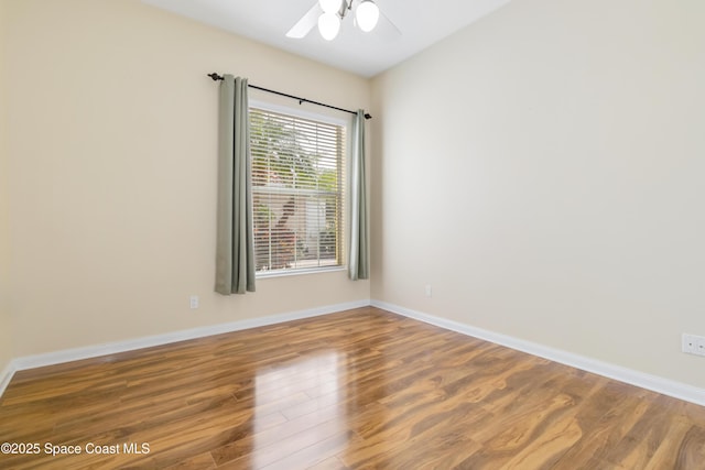 unfurnished room with a ceiling fan, baseboards, and wood finished floors