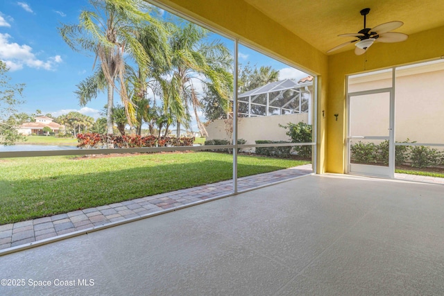 unfurnished sunroom with a water view and a ceiling fan