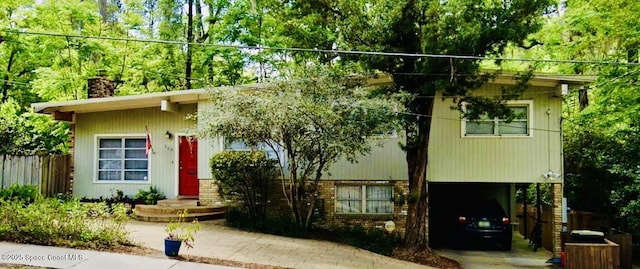 view of front of home featuring a chimney, fence, a carport, and brick siding