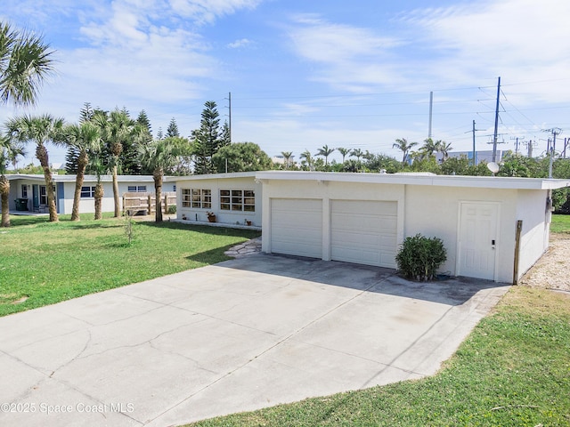 112 Sunset Dr, Cocoa Beach, FL 32931 - ranch-style house with a front yard, driveway, a garage, and stucco siding