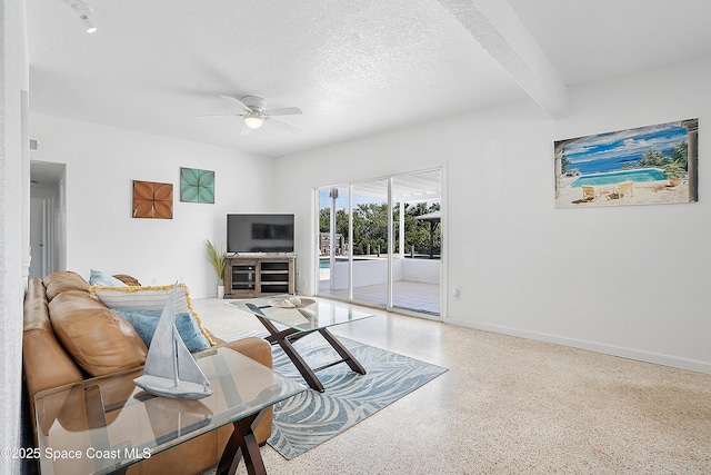 112 Sunset Dr, Cocoa Beach, FL 32931 - living room with speckle patterned floor, ceiling fan, beam ceiling, baseboards, and a textured ceiling
