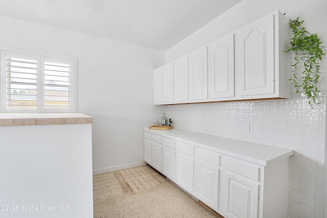 112 Sunset Dr, Cocoa Beach, FL 32931 - kitchen with white cabinetry, light countertops, and baseboards