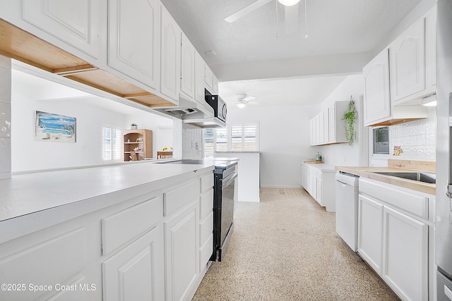 112 Sunset Dr, Cocoa Beach, FL 32931 - kitchen with white dishwasher, ceiling fan, electric stove, and white cabinetry