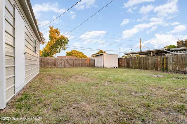 view of yard featuring a storage shed, an outdoor structure, and a fenced backyard