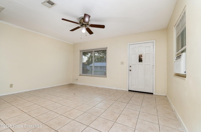 empty room with visible vents, baseboards, crown molding, and a ceiling fan