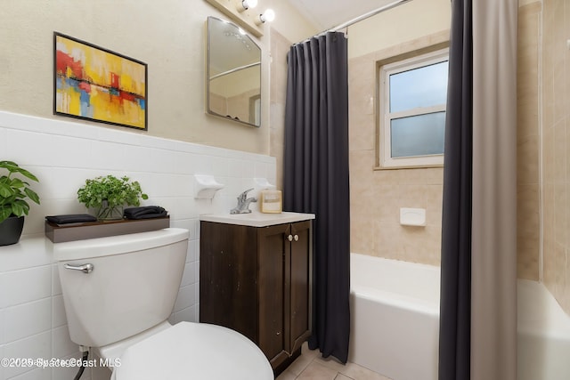 full bathroom featuring tile patterned floors, a wainscoted wall, toilet, tile walls, and vanity