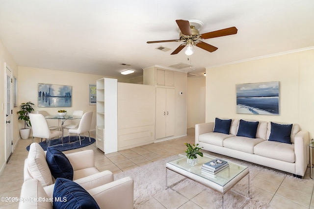 living room with ceiling fan, visible vents, light tile patterned flooring, and ornamental molding