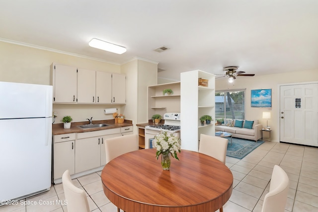 dining room featuring light tile patterned floors, visible vents, ceiling fan, and crown molding