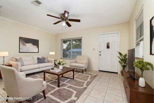 living area with visible vents, a ceiling fan, light tile patterned flooring, crown molding, and baseboards