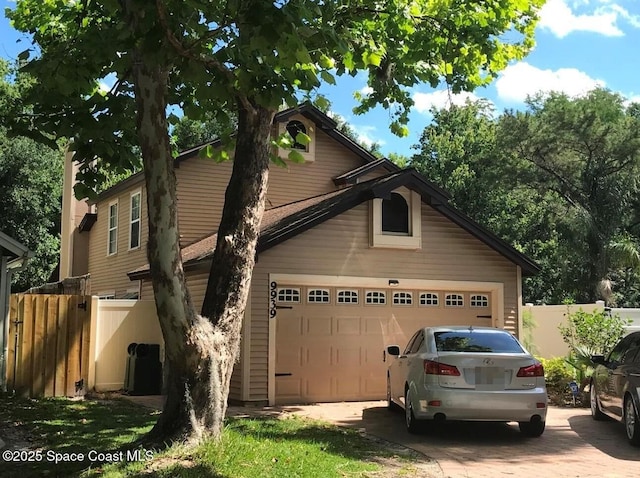 view of front of house featuring driveway and fence