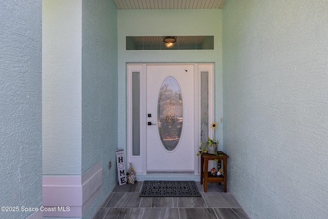 doorway to property featuring stucco siding