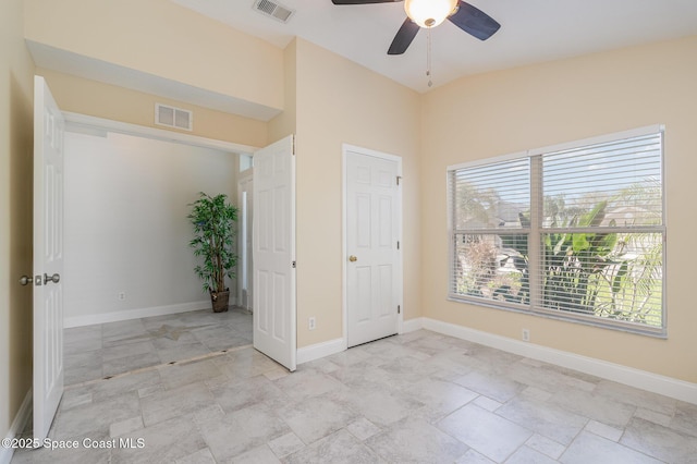 unfurnished bedroom with vaulted ceiling, a ceiling fan, visible vents, and baseboards