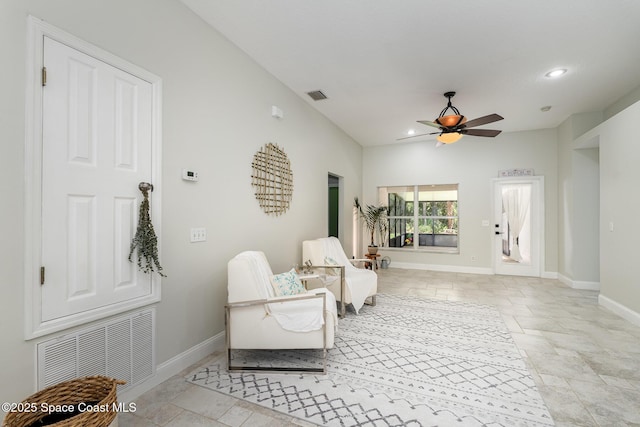 living area featuring a ceiling fan, lofted ceiling, visible vents, and baseboards