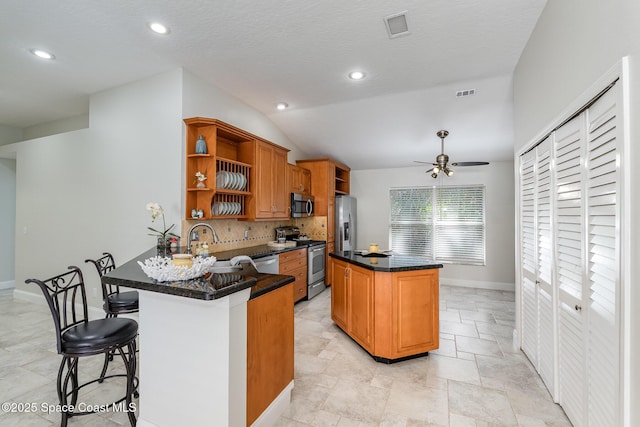 kitchen with tasteful backsplash, visible vents, dark countertops, stainless steel appliances, and open shelves