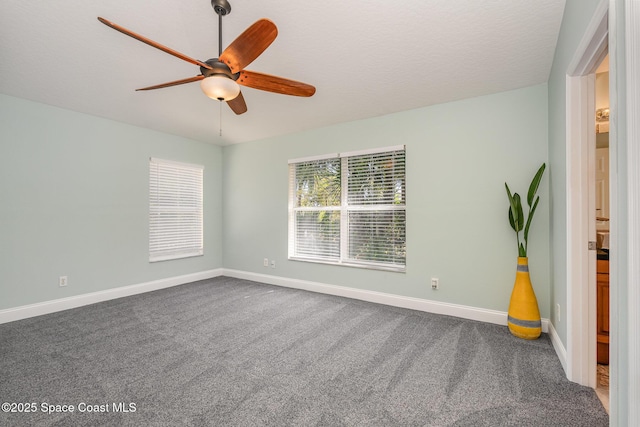 empty room featuring carpet floors, ceiling fan, and baseboards