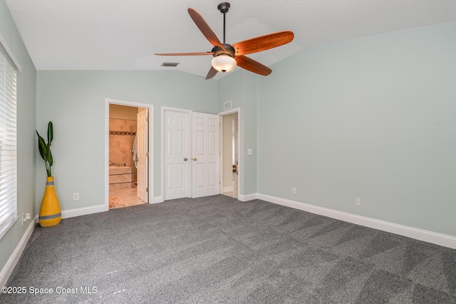 unfurnished bedroom featuring vaulted ceiling, carpet floors, visible vents, and baseboards