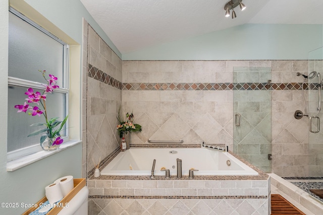 bathroom featuring a stall shower, a textured ceiling, vaulted ceiling, and a bath