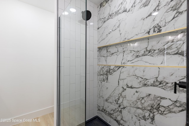 bathroom featuring tiled shower and wood finished floors