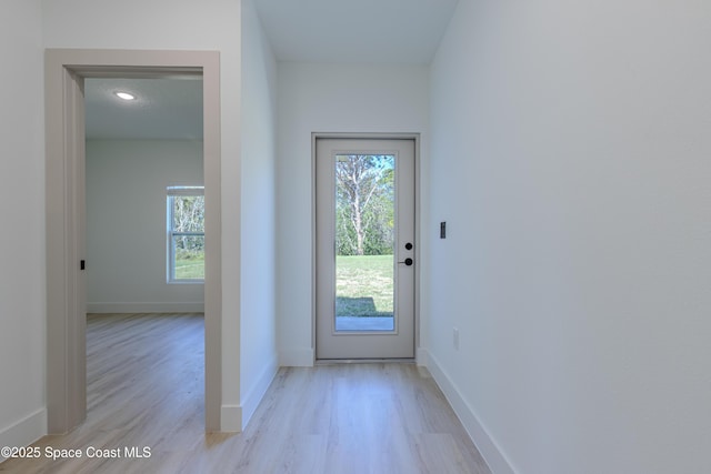 doorway to outside featuring light wood-style flooring and baseboards