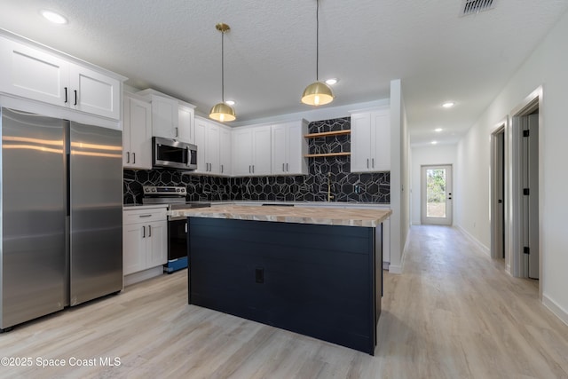 kitchen featuring appliances with stainless steel finishes, butcher block counters, decorative backsplash, and open shelves