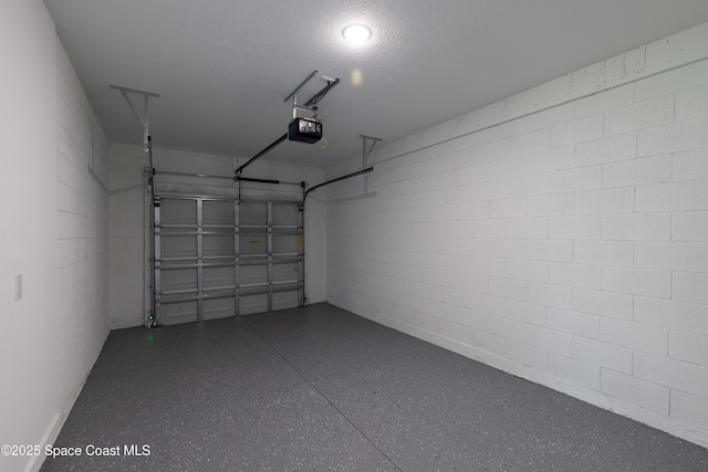 garage with concrete block wall and a garage door opener