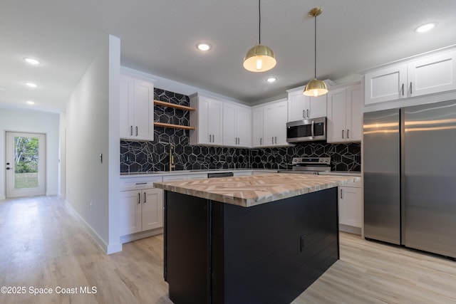 kitchen with decorative backsplash, wood counters, appliances with stainless steel finishes, light wood-type flooring, and open shelves