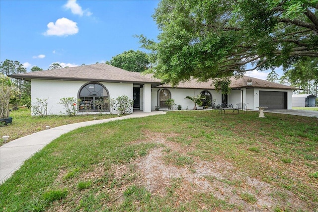 ranch-style house featuring an attached garage, driveway, and a front yard