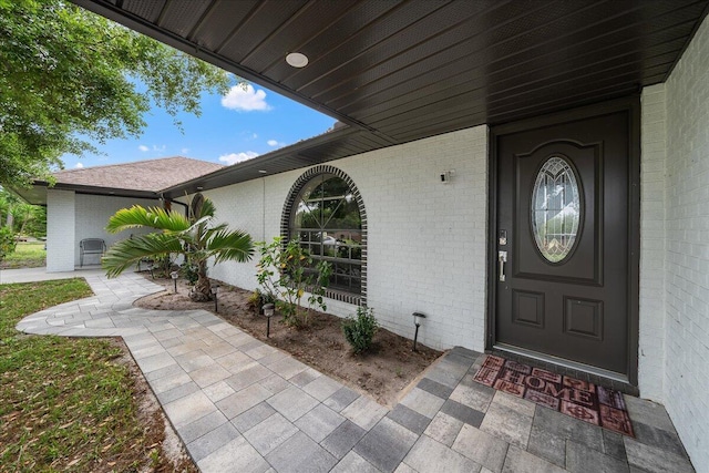 doorway to property with brick siding