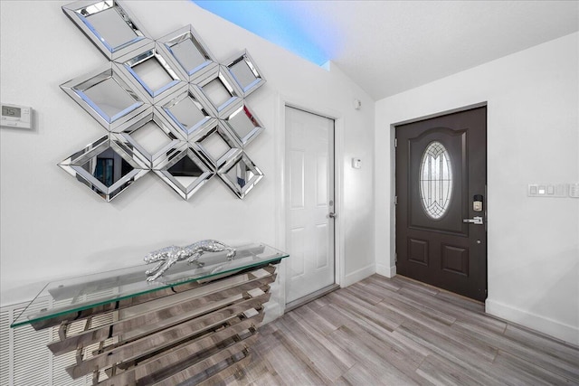 foyer with light wood finished floors and baseboards