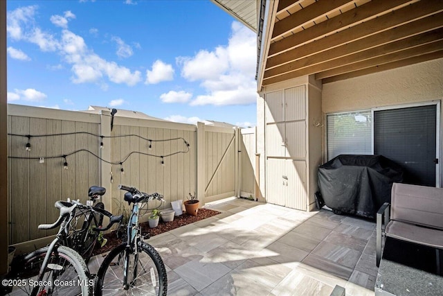 view of patio / terrace with area for grilling, a fenced backyard, and a gate