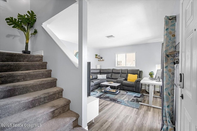 stairway featuring visible vents and wood finished floors